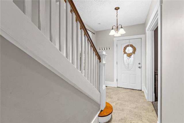 entrance foyer featuring a textured ceiling and an inviting chandelier