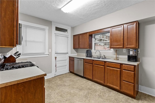 kitchen with appliances with stainless steel finishes, a textured ceiling, and sink