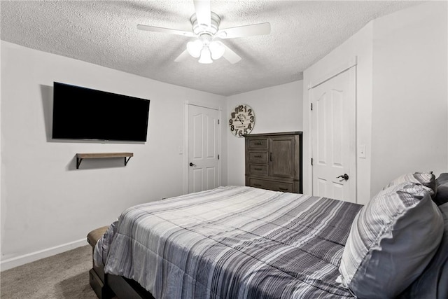 carpeted bedroom featuring ceiling fan and a textured ceiling