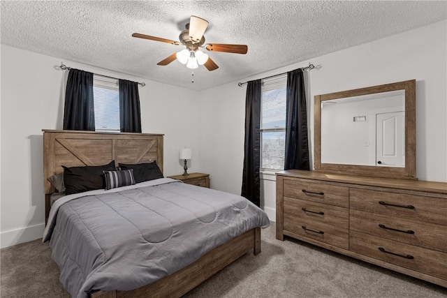 bedroom with ceiling fan, light colored carpet, a textured ceiling, and multiple windows