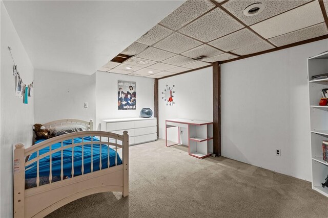 bedroom with light carpet and a drop ceiling