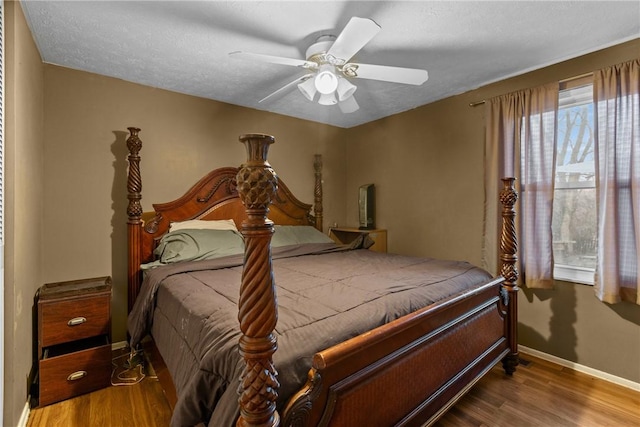 bedroom with ceiling fan, wood-type flooring, and a textured ceiling