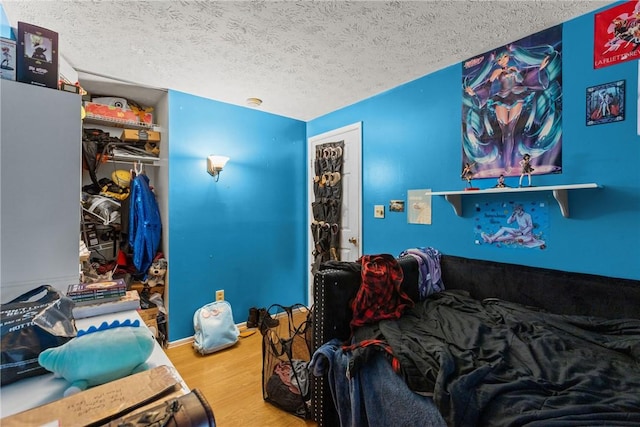 bedroom featuring hardwood / wood-style floors and a textured ceiling