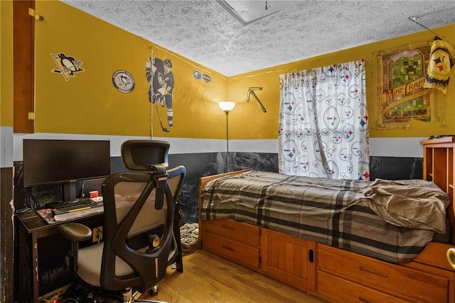 bedroom with a textured ceiling and light hardwood / wood-style floors