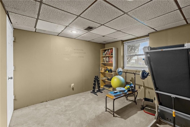 exercise room featuring carpet floors and a paneled ceiling