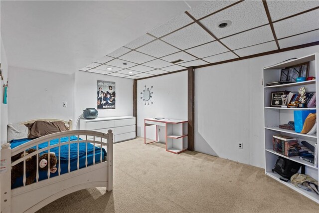 bedroom with a drop ceiling and carpet