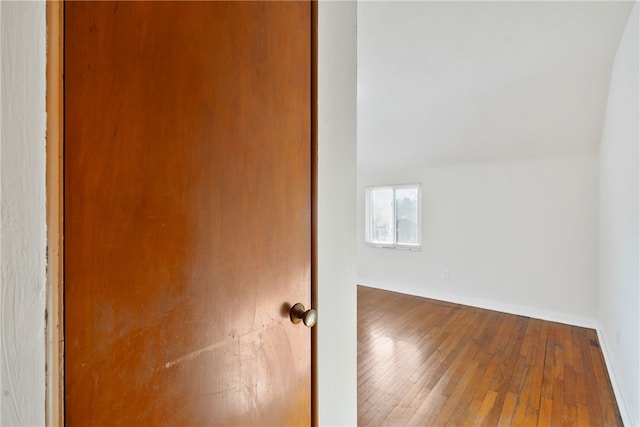 unfurnished room with baseboards and hardwood / wood-style floors