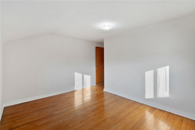 bonus room featuring baseboards, vaulted ceiling, and hardwood / wood-style floors