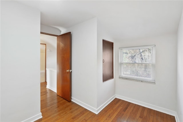 hallway featuring hardwood / wood-style floors and baseboards