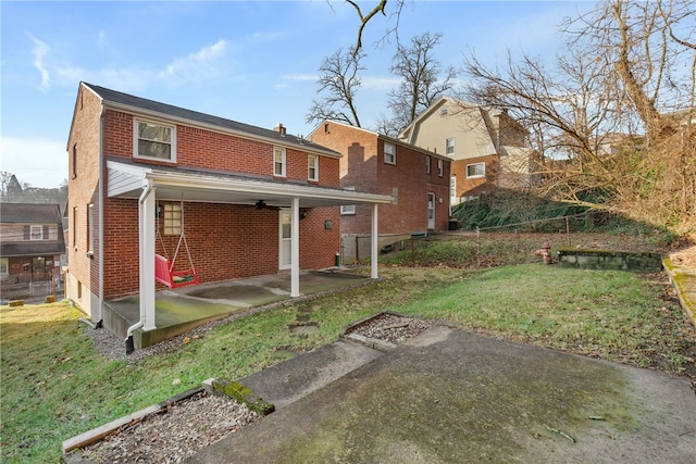 back of property with a patio, brick siding, and a lawn