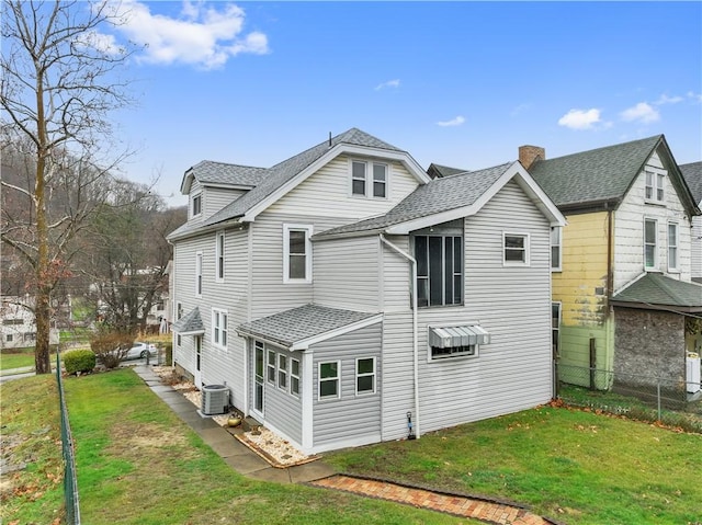 rear view of house featuring a yard and cooling unit