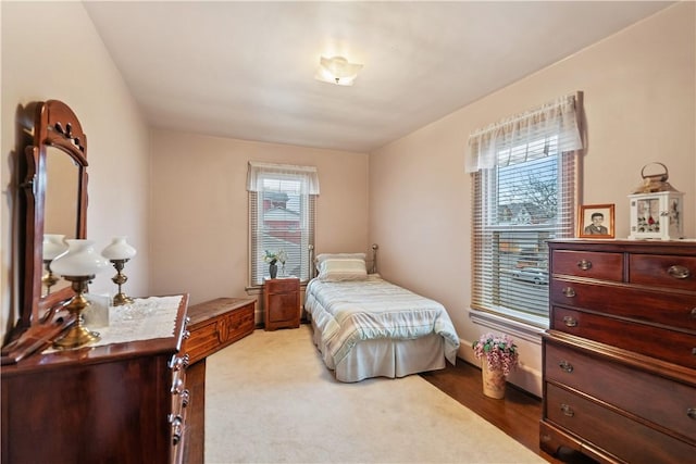 bedroom with multiple windows and hardwood / wood-style flooring