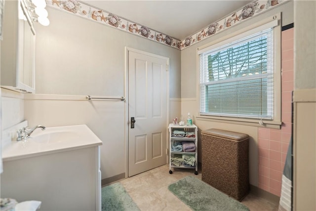 bathroom featuring vanity and tile walls