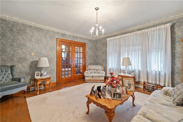 living room with an inviting chandelier, wood-type flooring, and french doors