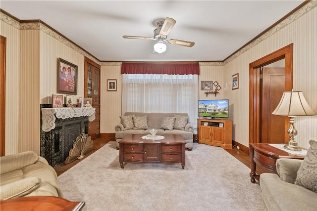 living room featuring hardwood / wood-style flooring, ceiling fan, and crown molding