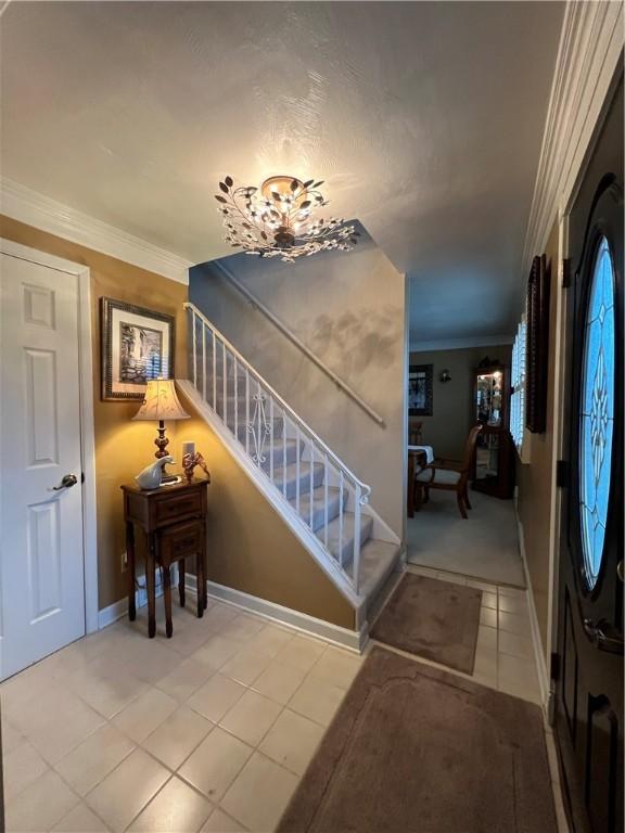 stairway with tile patterned flooring and ornamental molding