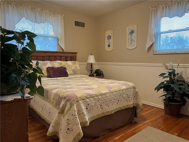 bedroom featuring wood-type flooring and multiple windows