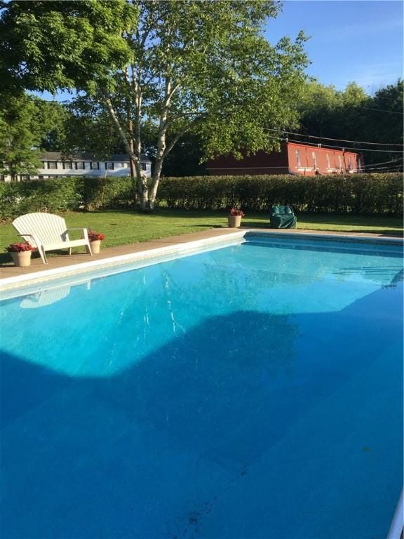 view of swimming pool with a lawn