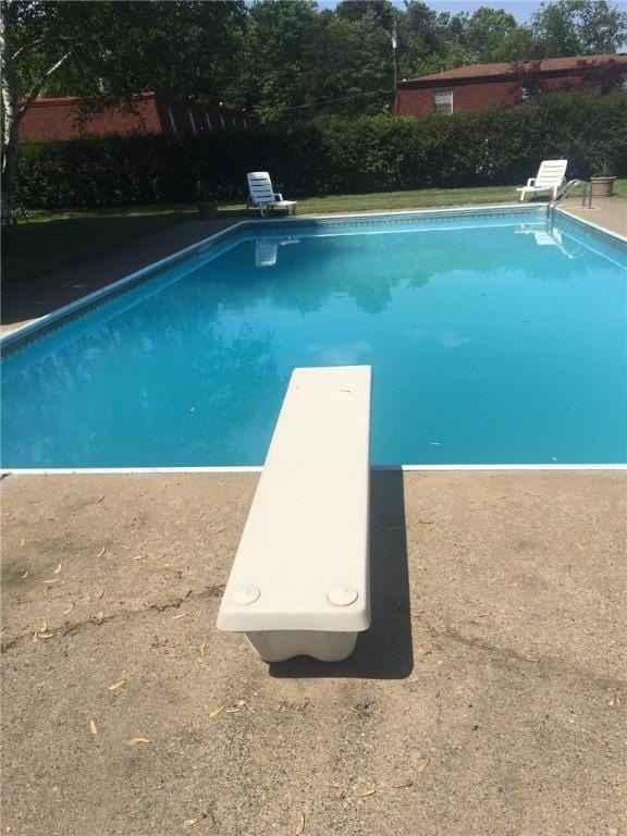 view of pool with a diving board