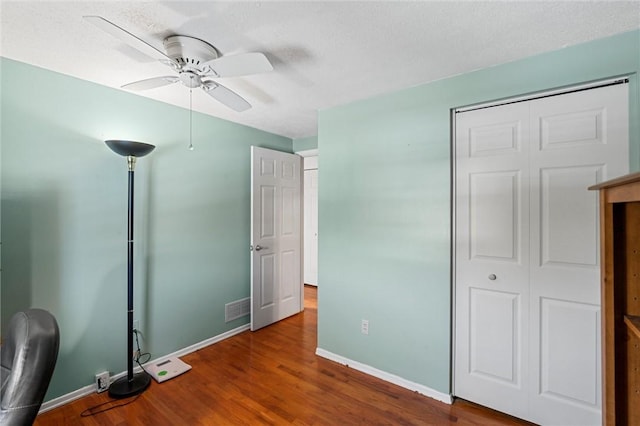 unfurnished bedroom featuring a closet, ceiling fan, hardwood / wood-style floors, and a textured ceiling