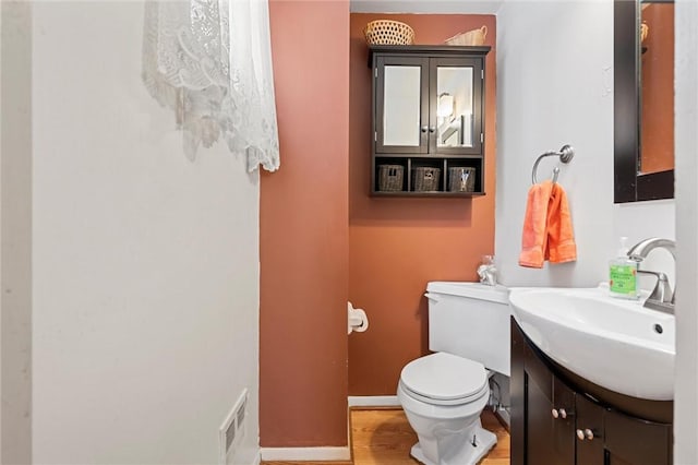 bathroom featuring hardwood / wood-style floors, vanity, and toilet