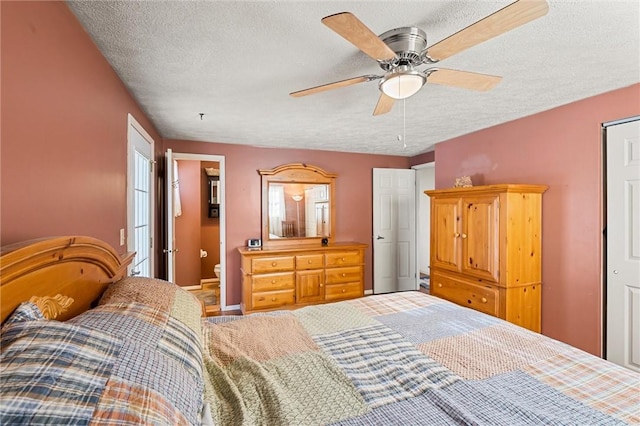 bedroom featuring ceiling fan, ensuite bathroom, and a textured ceiling