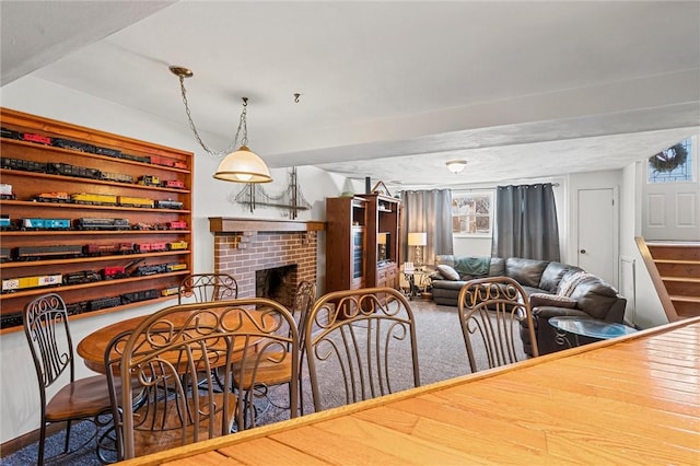 carpeted dining area with a brick fireplace