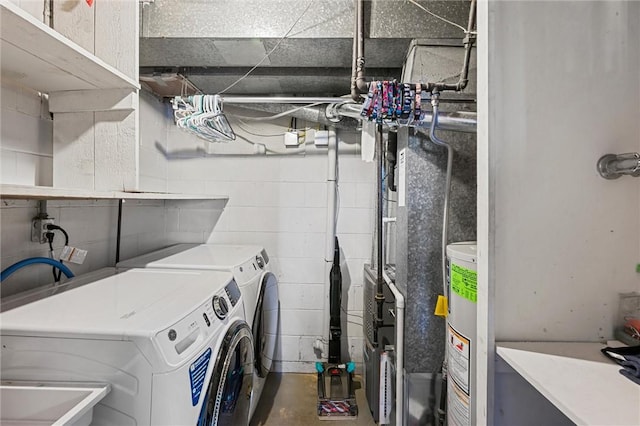 clothes washing area featuring independent washer and dryer and water heater