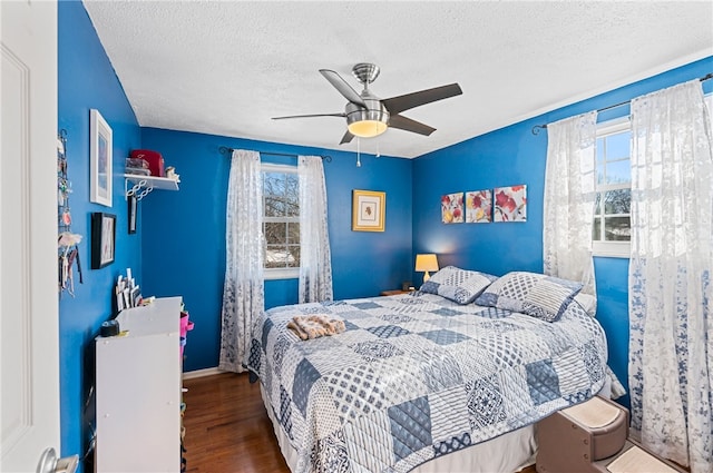 bedroom featuring a textured ceiling, ceiling fan, and dark wood-type flooring