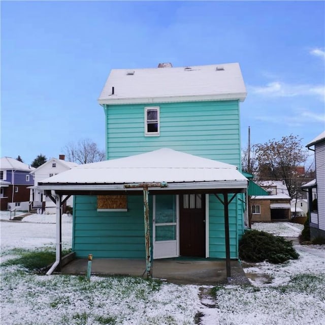 view of snow covered back of property