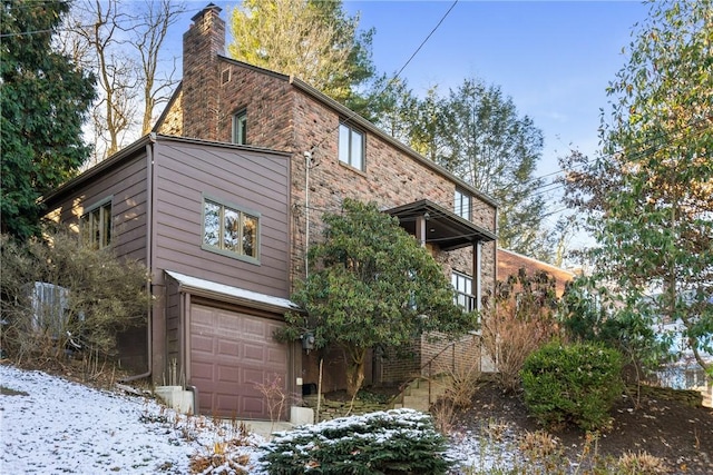 view of snowy exterior featuring a garage