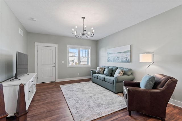 living room featuring a chandelier and dark hardwood / wood-style floors