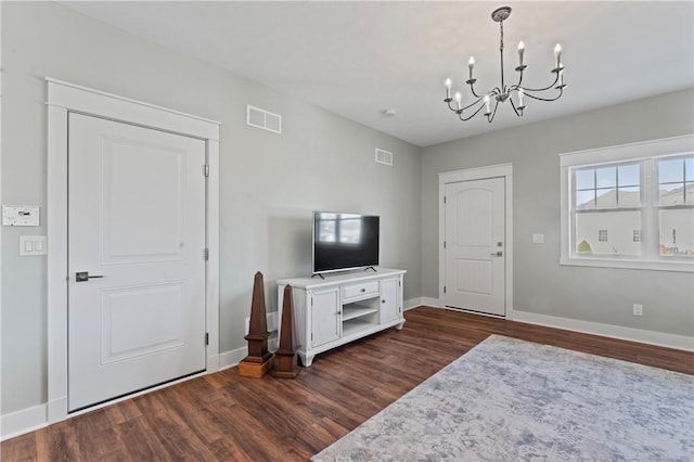 living room featuring dark wood-type flooring and a chandelier