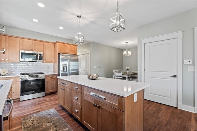 kitchen with a center island, dark hardwood / wood-style flooring, stainless steel appliances, and hanging light fixtures