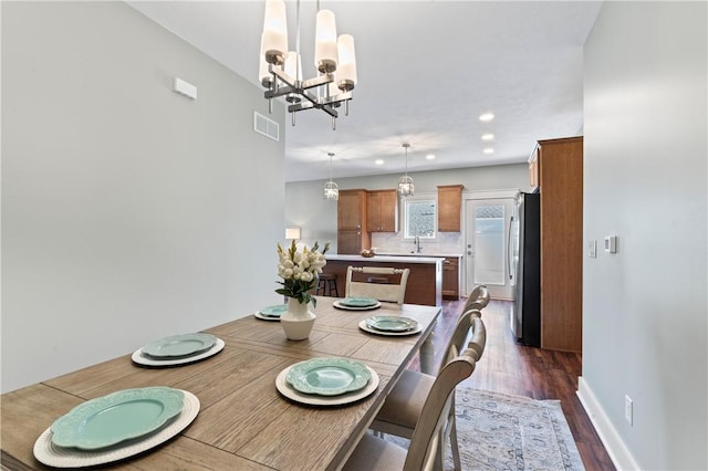 dining space featuring a chandelier, dark hardwood / wood-style floors, and sink