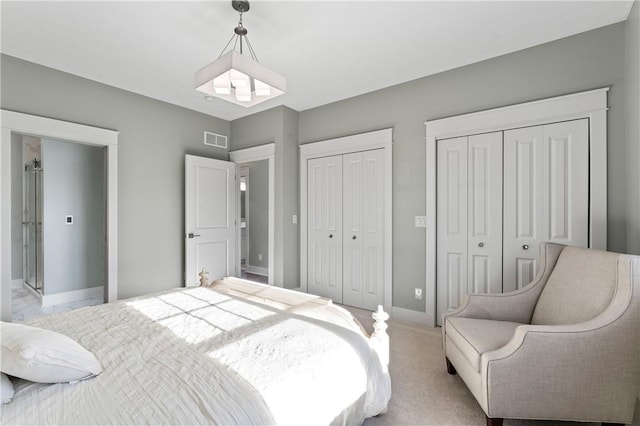 carpeted bedroom featuring multiple closets