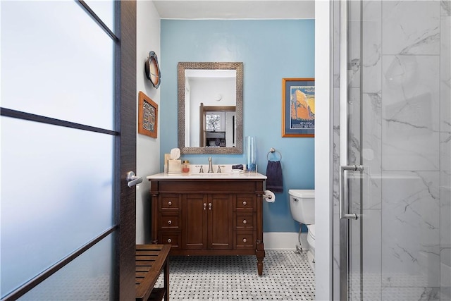 bathroom featuring vanity, a shower with shower door, and toilet