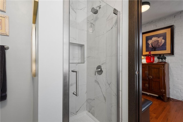 bathroom with wood-type flooring and a shower with door