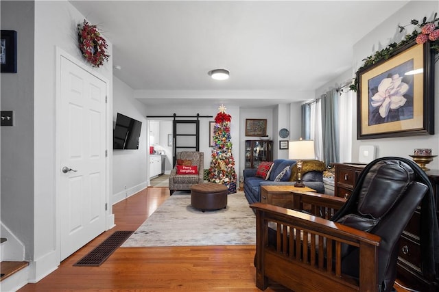 living room featuring a barn door and hardwood / wood-style flooring