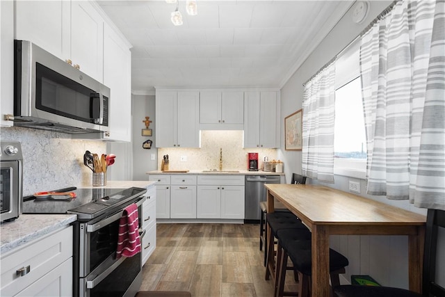 kitchen featuring sink, stainless steel appliances, tasteful backsplash, light hardwood / wood-style floors, and white cabinets