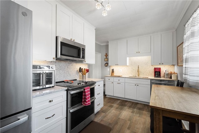 kitchen featuring sink, stainless steel appliances, dark hardwood / wood-style floors, decorative backsplash, and white cabinets