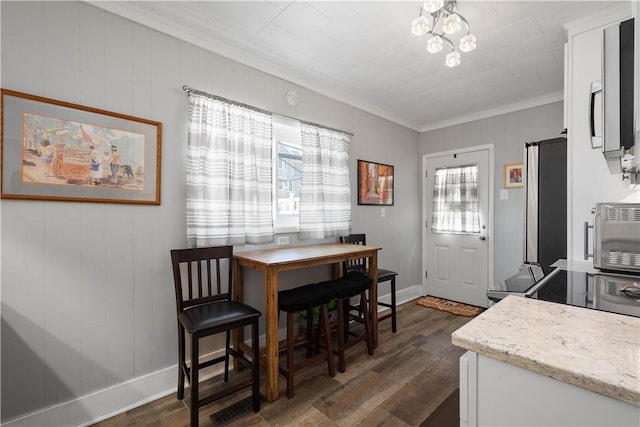 dining room with dark hardwood / wood-style flooring and ornamental molding