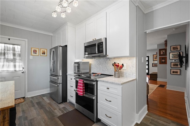 kitchen with white cabinetry, dark hardwood / wood-style flooring, stainless steel appliances, and ornamental molding