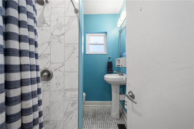 bathroom featuring a shower with curtain, toilet, and sink