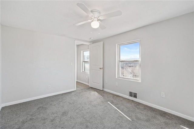 carpeted spare room featuring ceiling fan