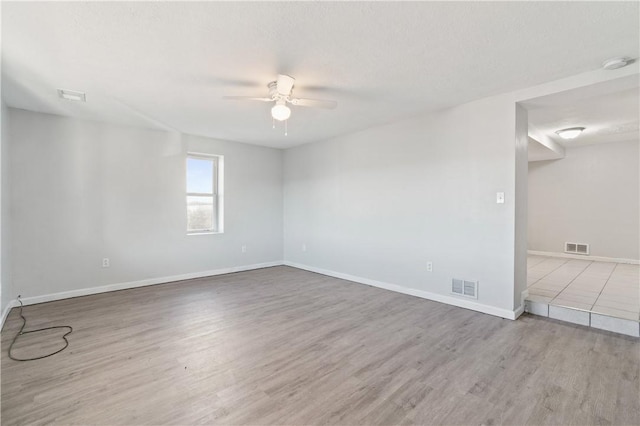 unfurnished room featuring ceiling fan, a textured ceiling, and light wood-type flooring