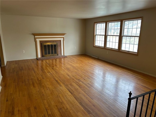 unfurnished living room with a fireplace and light hardwood / wood-style flooring