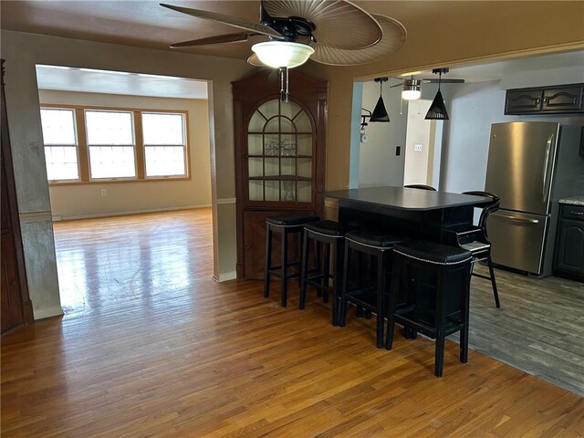 dining space with ceiling fan and light hardwood / wood-style flooring