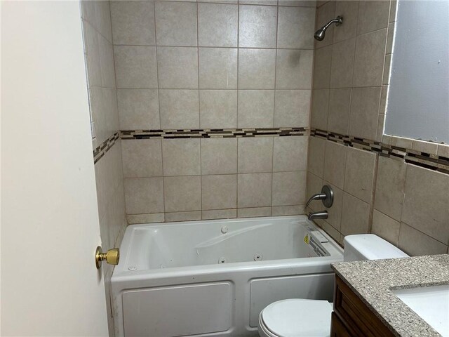 full bathroom featuring toilet, tile walls, tiled shower / bath, and vanity