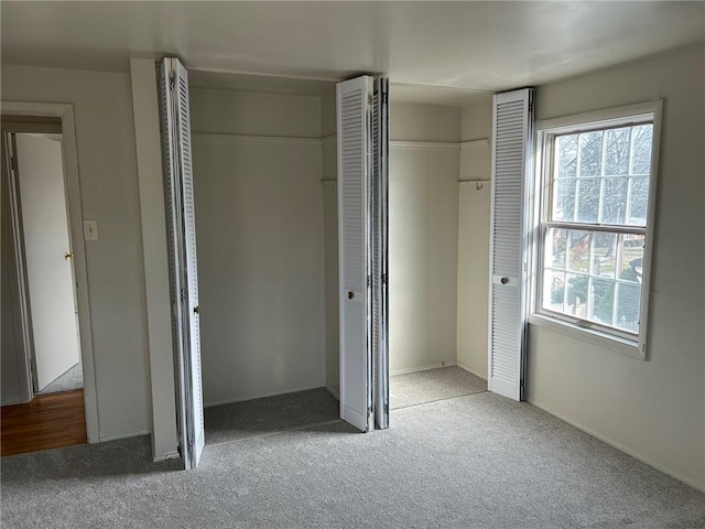 unfurnished bedroom with carpet floors and multiple closets